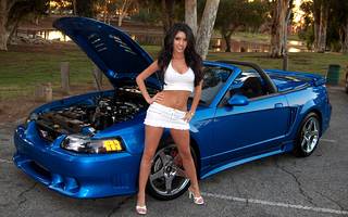 Girl in mini skirt and tight-fitting top, amid cool cars.